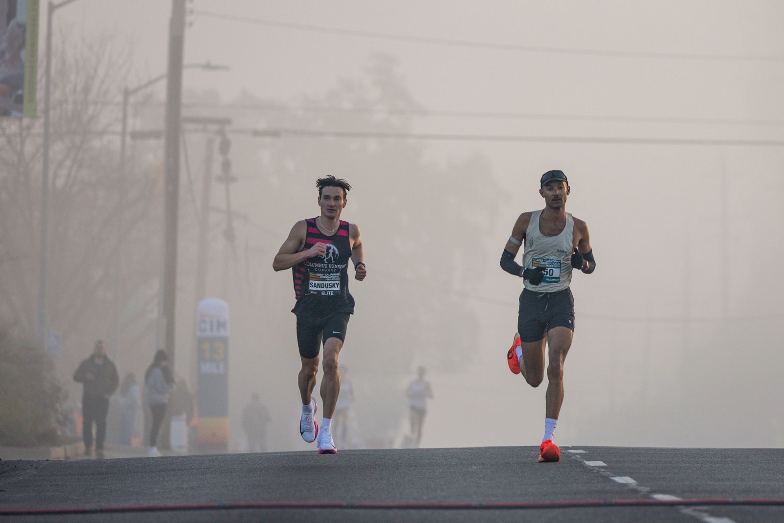 Coureurs de semi-marathon sur route dans la brume matinale